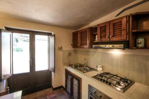 モンテ・アルジェンターリオにあるCasalino Spagnolo Cozy Apartmentのキッチン(コンロ、シンク付)、窓が備わります。