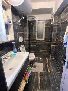 a bathroom with a sink and a toilet at Apartament 33 in Elbasan +6 photos
