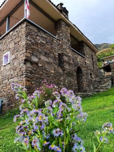 a stone building with a bunch of flowers in front of it at Gudani Temi in Gudani