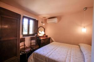 モンテ・アルジェンターリオにあるCasalino Spagnolo Cozy Apartmentのベッドルーム1室(ベッド1台、デスク、窓付)