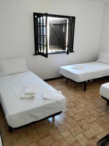 a room with two beds and a mirror on the wall at Conceição Guesthouse in Tavira
