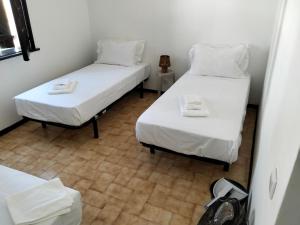 two beds in a small room with white sheets at Conceição Guesthouse in Tavira +11 photos