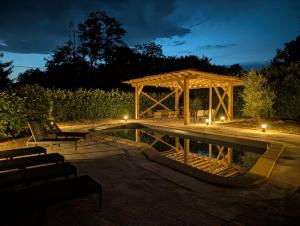 a gazebo and a swimming pool at night at Une histoire à écrire in Belleville-sur-Saône