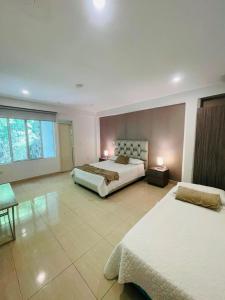 a large bedroom with two beds and a large window at Hotel Mall Roma in Pereira