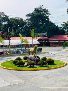 a statue of a horse on a roundabout in a parking lot at Hotel Mall Roma in Pereira