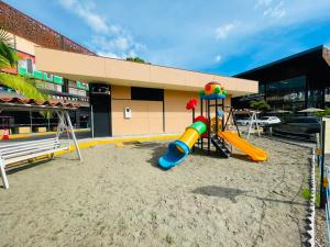 a playground in the sand in front of a building at Hotel Mall Roma in Pereira