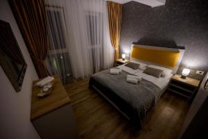 a bedroom with a large bed and two night stands at Central Rent Apartments in Suceava