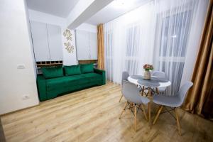 a living room with a green couch and a table at Central Rent Apartments in Suceava