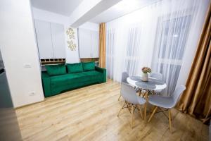 a living room with a green couch and a table at Central Rent Apartments in Suceava