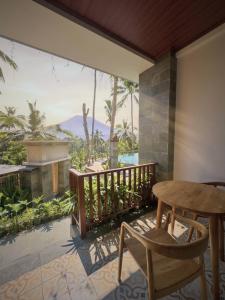 a patio with a table and chairs on a balcony at Puri Diamond Villas in Tampaksiring