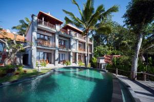 a swimming pool in front of a house at Puri Diamond Villas in Tampaksiring