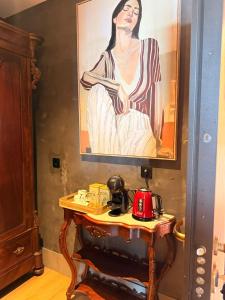 a painting of a woman on a wall next to a table at Al Dazk in Ribeira Brava