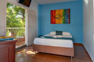 a bedroom with a bed with a painting on the wall at Casa Blanca in Santa Marta