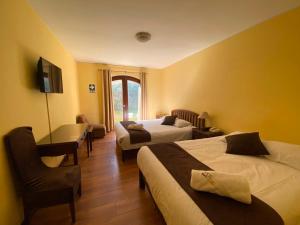 a hotel room with two beds and a desk at Hotel Meliana in Arequipa