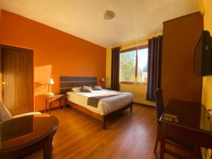 a bedroom with a bed and a large window at Hotel Meliana in Arequipa