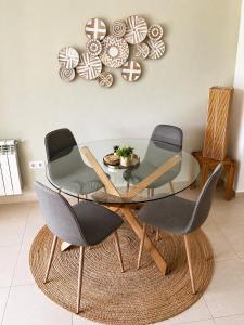 a glass dining room table with four chairs in a room at Casa Lilo - Renovated 2-Bed Apartment with Pool View - La Torre Golf Resort in Torre-Pacheco +23 photos