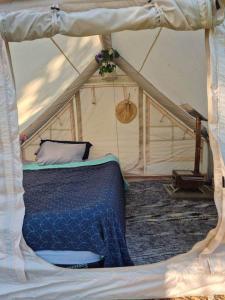 a bedroom with a bed in a tent at Tiny Timber Tent in West Danby