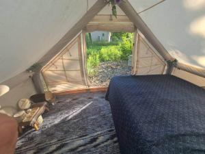 a room with a bed in a tent with a window at Tiny Timber Tent in West Danby