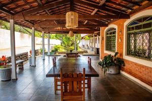 a patio with a wooden table and chairs at Pousada Refúgio Serrano in Serra Negra