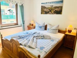 a bedroom with a bed with blue and white blankets and pillows at Da Lat Homestay - mit EisCafe in Bad Schandau