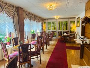 a dining room with tables and chairs and windows at Da Lat Homestay - mit EisCafe in Bad Schandau