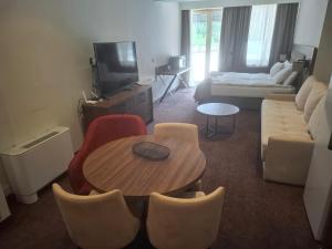 a living room with a table and a couch at Lunas Apartmani in Kopaonik