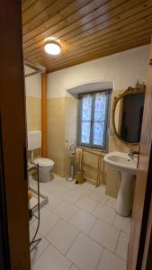 a bathroom with a sink and a toilet and a mirror at Antica osteria in Primaluna
