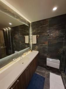 a bathroom with a sink and a tub and a mirror at Lunas Apartmani in Kopaonik