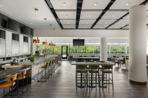 a restaurant with bar stools and tables and windows at Salt Lake City Marriott University Park in Salt Lake City
