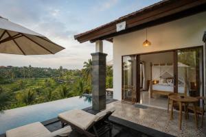 a villa with a swimming pool and a bedroom at Puri Diamond Villas in Tampaksiring