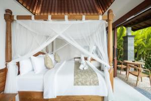a bedroom with a canopy bed in a villa at Puri Diamond Villas in Tampaksiring +76 photos