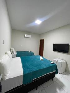 a bedroom with a bed and a flat screen tv at Hotel maria araujo in Arapiraca