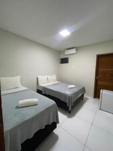 a hotel room with two beds and a tv at Hotel maria araujo in Arapiraca