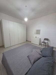 a bedroom with a large bed and a chair at Puteoli Stop vacation home in Pozzuoli