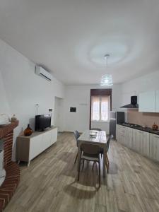 a living room with a table and a kitchen at Puteoli Stop vacation home in Pozzuoli