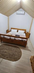 a large bed in a room with a rug at Cabana Relax in Râmnicu Vâlcea +5 photos