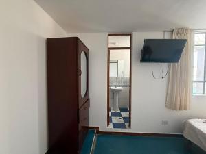 a bedroom with a mirror and a sink and a tv at Oasis in Tacna