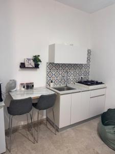 a kitchen with a sink and a counter with chairs at קסם צפתי- סטודיו in Safed