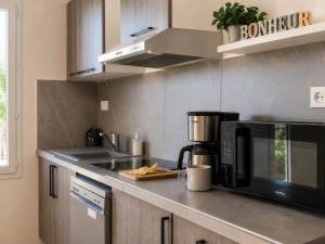 a kitchen with a microwave and a coffee maker on a counter at Le temps de la pause 2 in Cepoy
