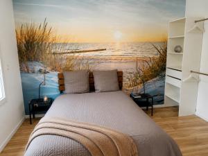 a bedroom with a bed with a painting of the ocean at Le temps de la pause 2 in Cepoy +14 photos