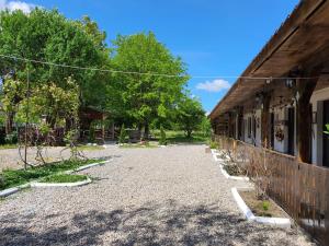 a house with a gravel driveway next to a building at La Romaneasa in Săpânța