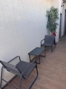 two chairs and a table next to a wall at קסם צפתי in Safed