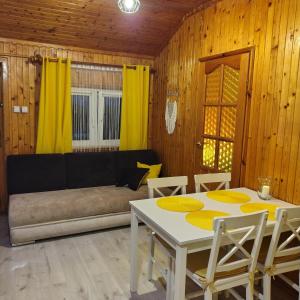 a living room with a couch and a table and chairs at Domek u Prezesa in Kłótno