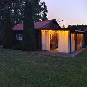 a house with a garage with lights on it at Domek u Prezesa in Kłótno