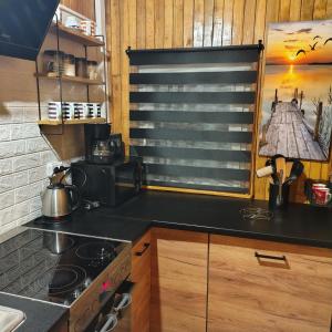 a kitchen with a stove and a counter top at Domek u Prezesa in Kłótno