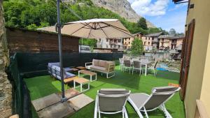 eine Terrasse mit Stühlen, einem Tisch und einem Sonnenschirm in der Unterkunft La Ràndula in Balme