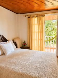 a bedroom with a large bed and a window at La Cabaña Paraíso Verde Suaita in Suaita +74 photos