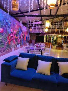 a blue couch in a room with tables and chairs at La Cabaña Paraíso Verde Suaita in Suaita