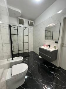 a bathroom with a sink and a toilet and a mirror at Casa Birmano in Taranto