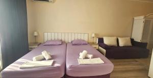 a bedroom with a large bed and a couch at Sun Sea 2 in Shkorpilovtsi +27 photos